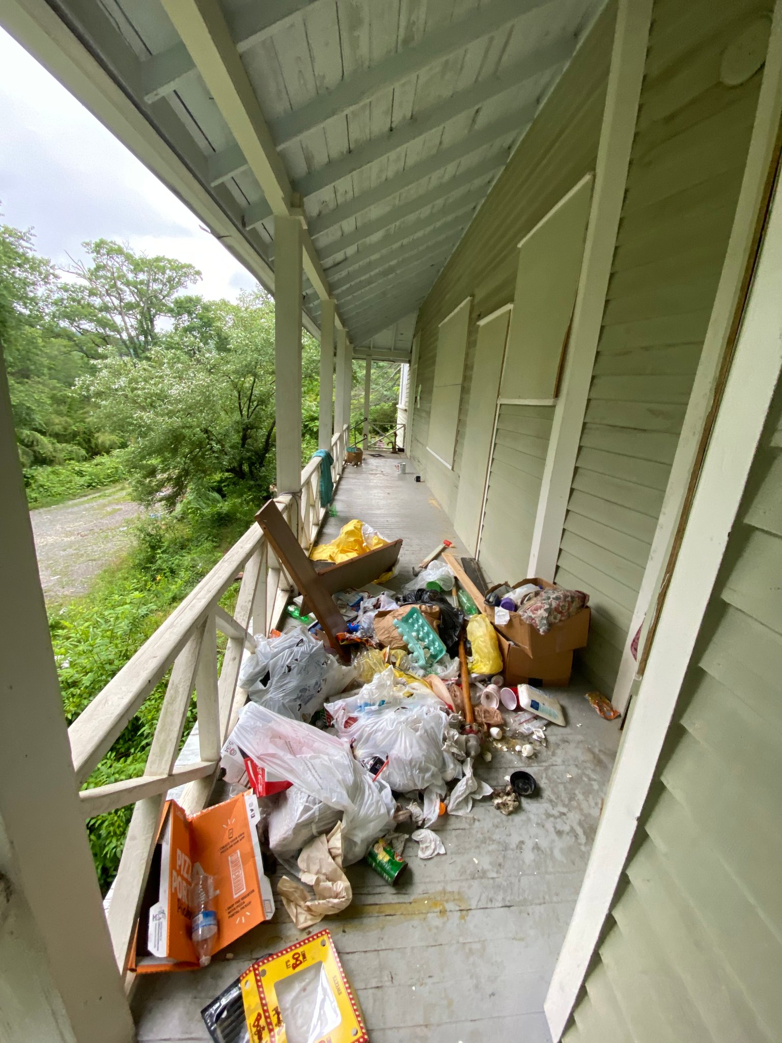 Porch — trash & debris piled throughout