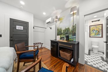 Bedroom corner with dark wood fireplace, mirror, and bathroom view