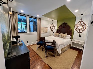 Bedroom with nautical decor, green accent wall, and ship wheel art