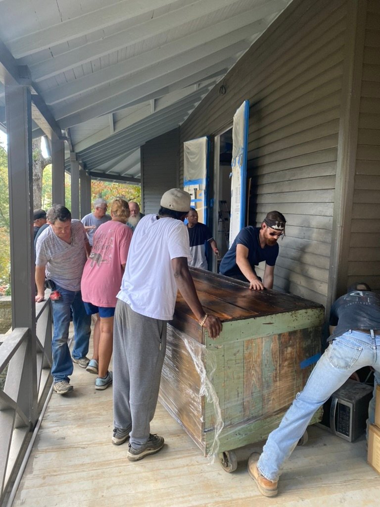 Moving day — the whole crew hauling the antique bar into the Wine Cellar