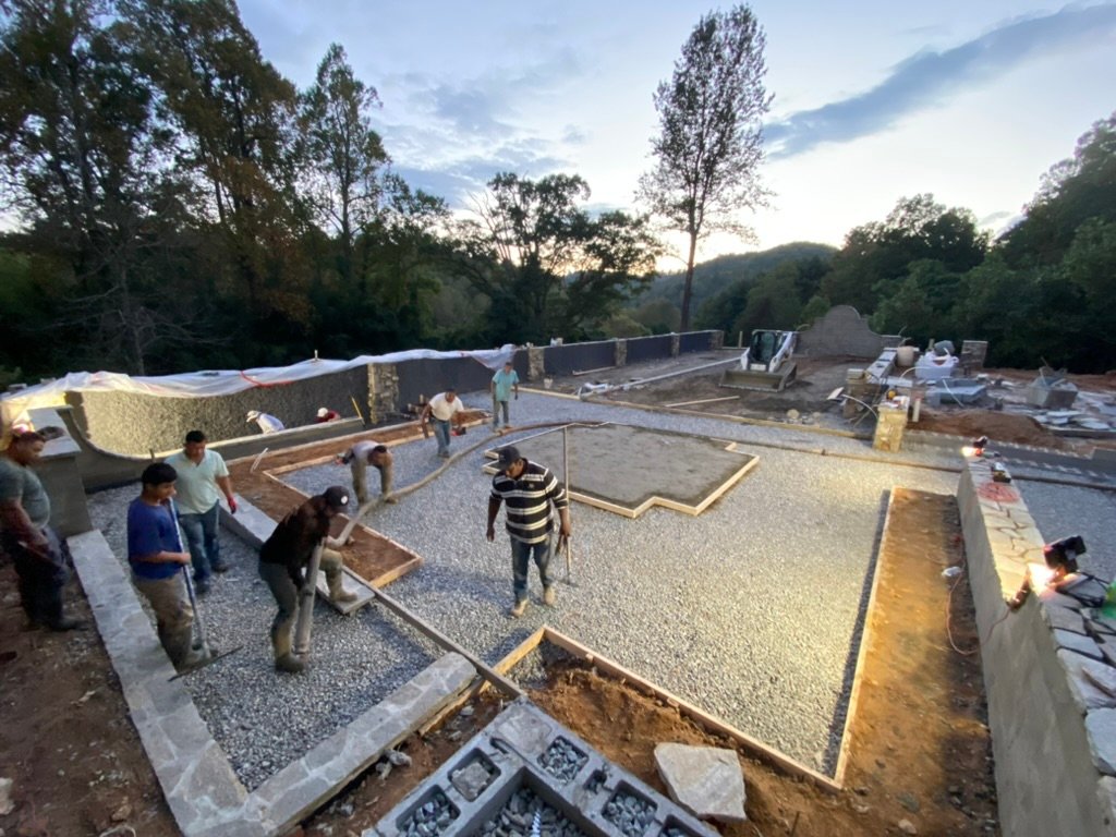 Gravel prep at dusk — crew setting forms for the Grand Lawn Terrace slab